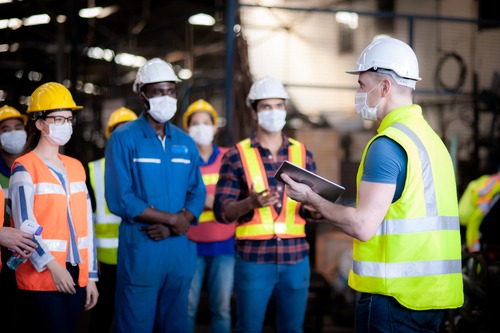male worker explaining best conveyor belt safety practices to team