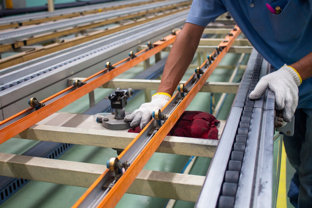 Technician cleaning conveyor belt